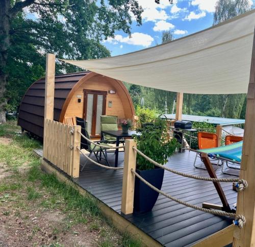 une cabine avec une terrasse et une tente dans l'établissement Tiny House Carlos, à Stuer
