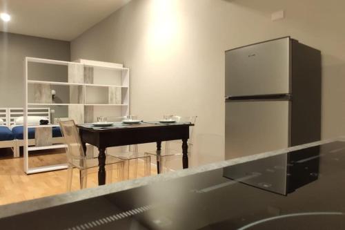 a kitchen with a table with chairs and a refrigerator at Elegante appartamento Zona Duomo in Milan