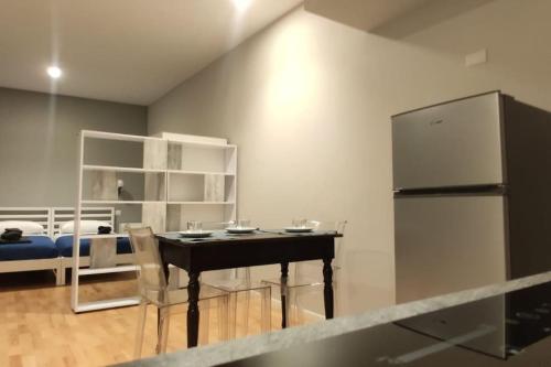 a kitchen with a black table and a refrigerator at Elegante appartamento Zona Duomo in Milan