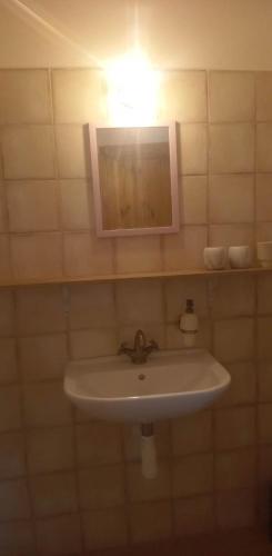 a white sink in a bathroom with a light at Restaurace a penzion Ubrousku prostři se in Nová Bystřice