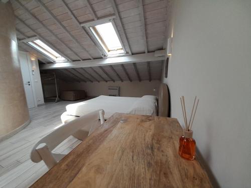 um quarto com uma mesa de madeira e uma cama em AMA AFFITTACAMERE em Albenga