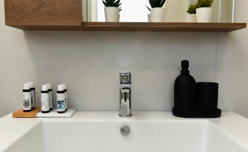 a sink with three bottles on a counter top at Katerina's Place in Argos