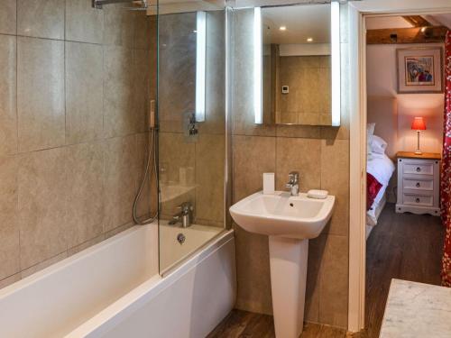 een badkamer met een douche, een wastafel en een bad bij Skylarks Nest in Witton