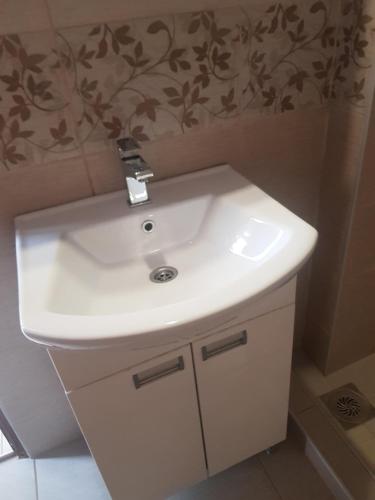 bagno con lavandino bianco in camera di Apartmani Strahinic a Leskovac