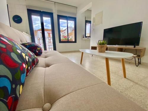 a living room with a couch and a tv at Dúplex en pleno centro de Écija in Écija