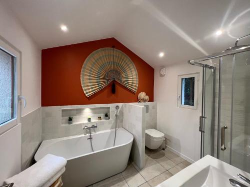 La salle de bains est pourvue d'une baignoire, d'une douche et de toilettes. dans l'établissement Casa Melodia, à Pontoise