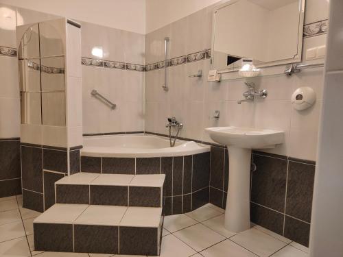 a bathroom with a sink and a tub and a toilet at Hotel Hutnik in Stalowa Wola