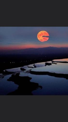 a full moon rising over a body of water at OzenTurku Hotel in Pamukkale