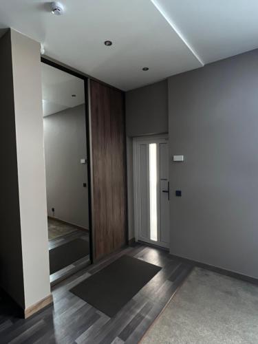 um quarto vazio com um corredor com uma porta em Vėtrungės Apartamentai em Klaipeda