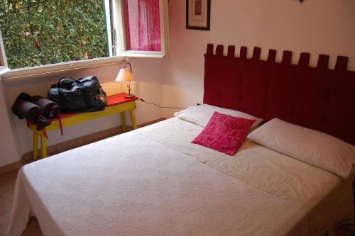 een slaapkamer met een wit bed en een roze kussen bij Sweet Cecina Mare in Cecina