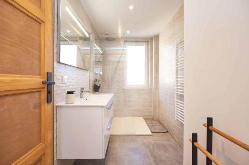 ein Badezimmer mit einem weißen Waschbecken und einem Spiegel in der Unterkunft Appartement Modane Wifi stationnement gratuit in Modane