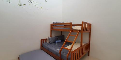 a bunk bed in a room with a ladder at Licuala Homestay Bukit Keluang in Kampung Raja