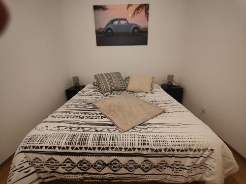 - un lit dans une chambre avec une photo d'une voiture sur le mur dans l'établissement Appartement rez-de-chaussé dans une petite ville au pied du massif des Vosges, à Saverne