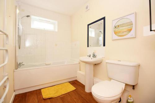 uma casa de banho branca com um WC, uma banheira e um lavatório. em Hidden Gem of Newark - Sleeps 6 em Ollerton