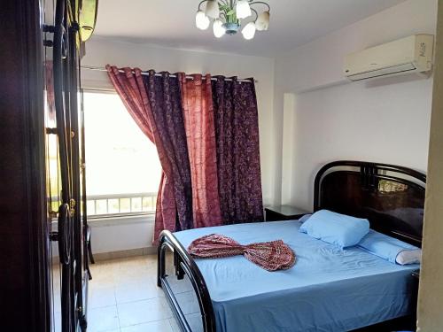 a bed in a room with a window and a bedvisor at Marina Wadi Degla villa duplex 4 Rooms Ain Sokhna in Ain Sokhna