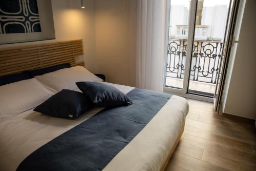 a bedroom with a bed with two pillows and a balcony at La Cementina in Bari