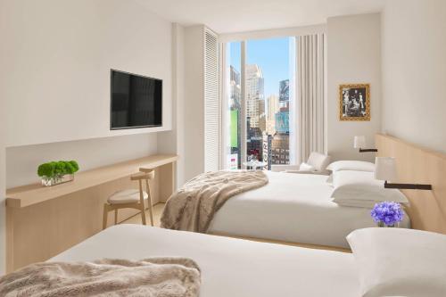 a hotel room with two beds and a tv at The Times Square EDITION New York in New York