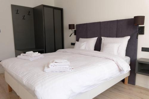 a bedroom with a large white bed with towels on it at Apartament e-Space in Rzeszów