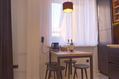 a kitchen with a table with bottles of wine on it at Apartament e-Space in Rzeszów