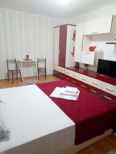 1 dormitorio con 1 cama blanca grande con manta roja en Apartament Modern Family, en Târgu Ocna