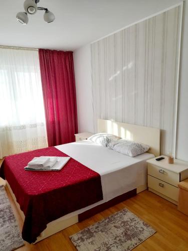 um quarto com uma cama grande e um cobertor vermelho em Apartament Modern Family em Tîrgu Ocna