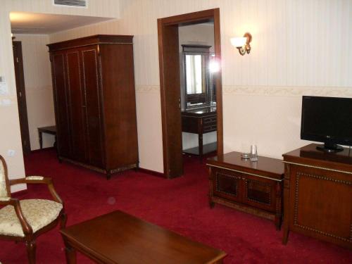 a living room with a tv and a chair and a table at Motel Hanat in St. St. Constantine and Helena