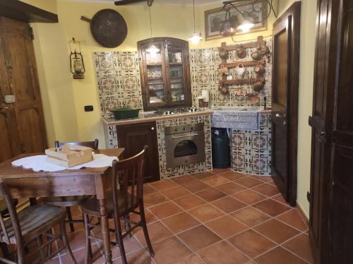 uma cozinha com uma mesa, um fogão e um forno em La torre della manca suite em Sasso di Castalda