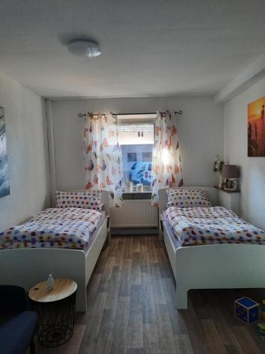 a bedroom with two beds and a window at Ferienwohnung am Rittershof Heusweiler in Heusweiler