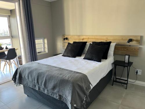 sypialnia z dużym łóżkiem z drewnianym zagłówkiem w obiekcie Port St Francis - QuarterDeck w mieście St Francis Bay