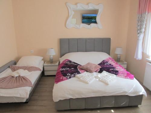 a bedroom with two beds and a mirror on the wall at Apartamenty Anagora Kotlina Kłodzka I in Nowa Ruda