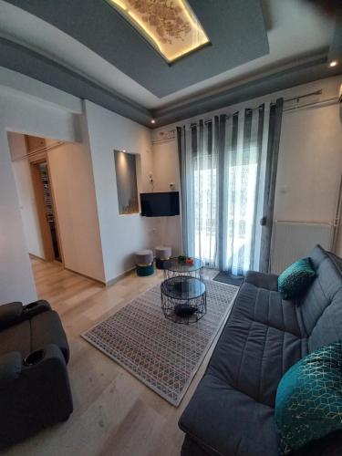 uma sala de estar com um sofá e uma mesa em A&D Central Apartment em Volos