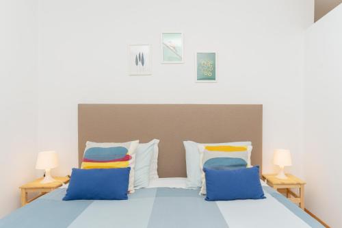 1 dormitorio con 1 cama con almohadas azules y amarillas en Sunny Oporto, Douro Apartments, en Oporto