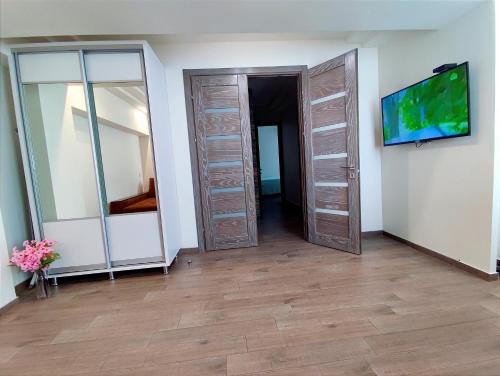 a room with wooden doors and a tv on a wall at 2BR+living downtown Chișinău in Chişinău