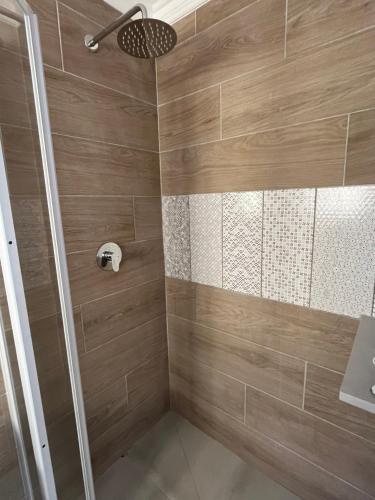 W łazience z drewnianymi ścianami znajduje się prysznic. w obiekcie Port St Francis - QuarterDeck w mieście St Francis Bay