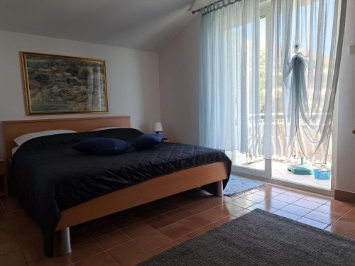 1 dormitorio con cama y ventana grande en Apartmani Beba en Trogir