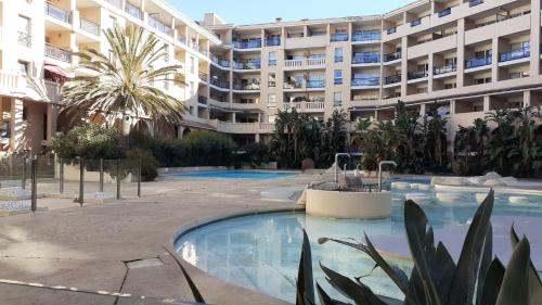 a large apartment building with a large swimming pool at appartement les pieds dans l'eau in Cannes