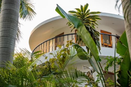 a white building with a balcony and palm trees at Anchorage 42 in Chandīgarh