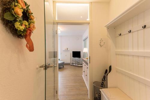 a hallway with a door with a flower wreath on it at Am Horumertief in Wangerland