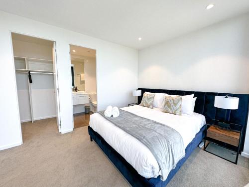 a bedroom with a large bed and a bathroom at Deluxe 3 Bedroom Apartment in Southbank in Melbourne