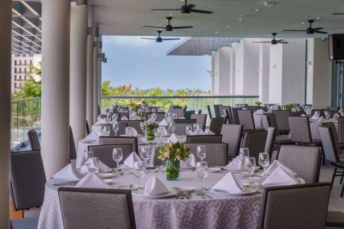 a banquet hall with white tables and chairs at Renaissance Cancun Resort & Marina in Cancún