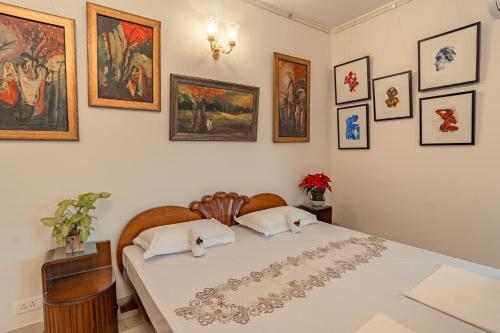 a bedroom with a bed with pictures on the wall at Anchorage 42 in Chandīgarh
