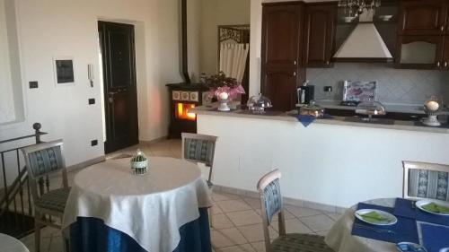 kuchnia ze stołem, krzesłami i kuchenką w obiekcie Villa dei Fantasmi w mieście Rocca di Papa