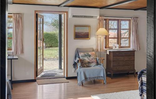 a room with a chair and a desk and windows at 2 Bedroom Nice Home In Harpelunde in Harpelunde