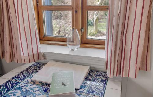 a book sitting on a table next to a window at 2 Bedroom Nice Home In Harpelunde in Harpelunde