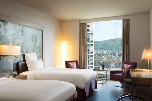 a hotel room with two beds and a large window at Renaissance Zurich Tower Hotel in Zurich