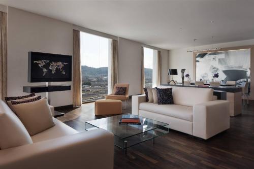 a living room with white couches and a table at Renaissance Zurich Tower Hotel in Zürich