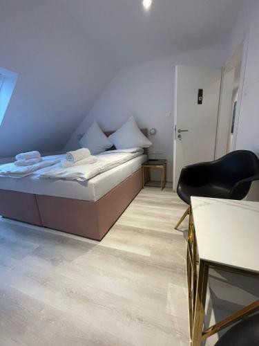 a bedroom with a bed and a chair and a table at ROYAL APARTMENTS in Lunca de Sus