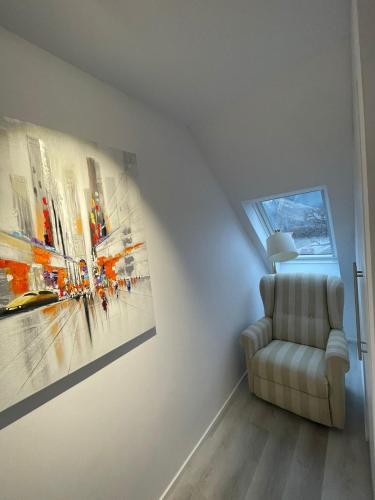 a room with a chair and a painting on the wall at ROYAL APARTMENTS in Lunca de Sus