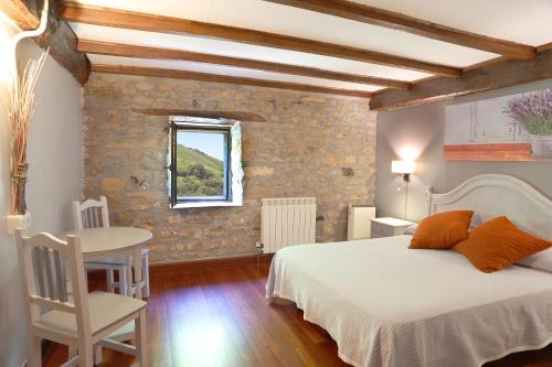 a bedroom with a bed and a table and a window at Casa Rural Haitzetxea in Zugarramurdi
