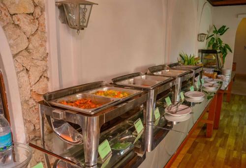 a buffet line of trays of food in a room at Best Western Jangwani Sea Breeze Resort in Dar es Salaam